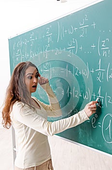 The young female math teacher in front of chalkboard