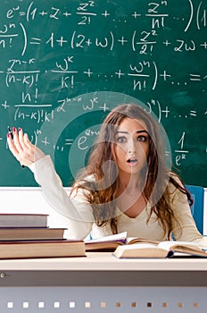 The young female math teacher in front of chalkboard