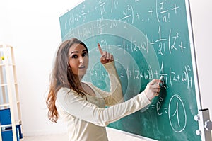 The young female math teacher in front of chalkboard