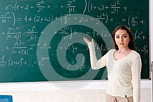 The young female math teacher in front of chalkboard