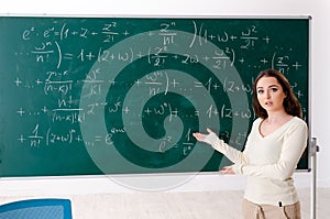 The young female math teacher in front of chalkboard