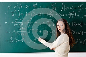 Young female math teacher in front of chalkboard