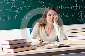 Young female math teacher in front of chalkboard