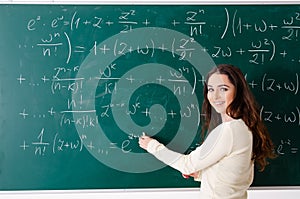 The young female math teacher in front of chalkboard