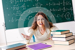 Young female math teacher in front of chalkboard