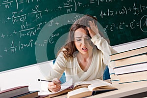 Young female math teacher in front of chalkboard