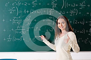 The young female math teacher in front of chalkboard