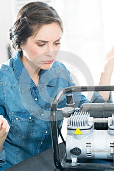 young female mechanic inspecting engine