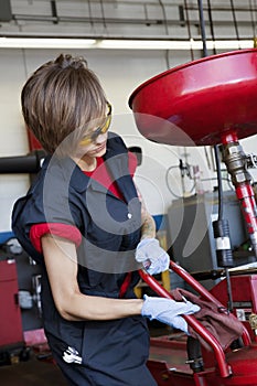 Young female mechanic working on welding equipment