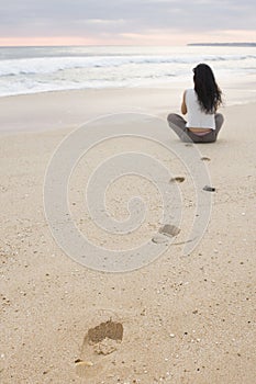 Giovane una donna meditazione sul silenzioso Spiaggia 