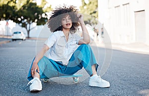 A young female mixed race woman skate sitting on a skateboard looking cool and confident with great style in a street