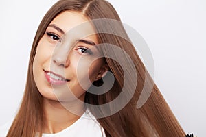 Young female model with beautiful long hair combs his comb