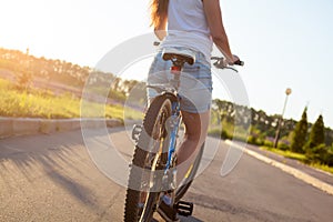 Young female model on bike, rear view