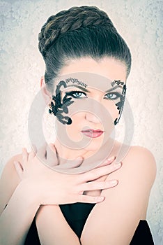 Beautiful Caucasian Model With Decorative Lace and Black Tattoo on Her Face, Touching Her Chest, on White Lace Background