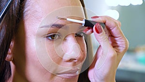 young female model getting professional eyebrow shape correction at beauty salon