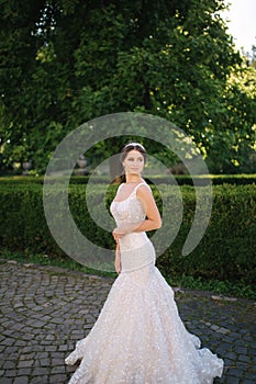 Young female model in wedding dress outdoors. Fashion photo of bride