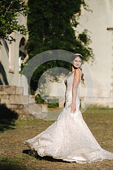 Young female model in wedding dress outdoors. Fashion photo of bride