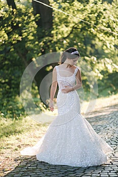 Young female model in wedding dress outdoors. Fashion photo of bride