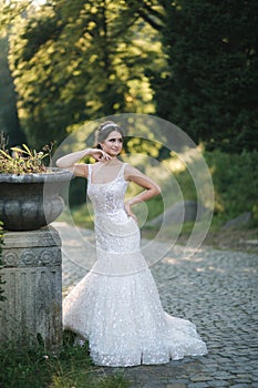 Young female model in wedding dress outdoors. Fashion photo of bride