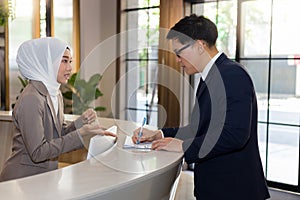 Young female Muslim receptionists are introducing hotel stays to travelers