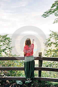 Young female nature explorer enjoying the view from viewpoint