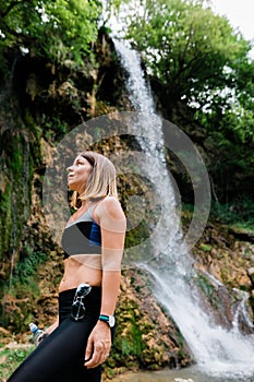 Young female nature explorer by the waterfall