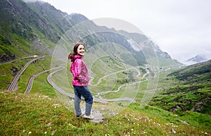 Young female in nature landscape with Transfagarashan Highway at background