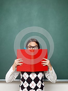 Young female nerd holding book