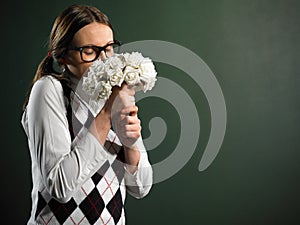 Young female nerd smelling bouquet of flowers