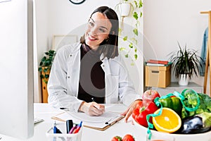 Young female nutritionist talking with patient through computer video call