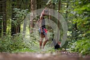 Young female obedience trainer  training her black labrador puppy