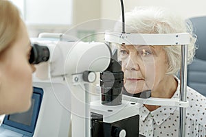 Young female ophthalmologist using apparatus photo