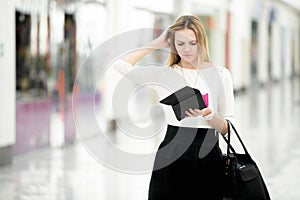 Young female out of money checking her purse in disbelief