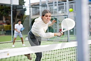 Young female paddle tennis player performing backhand