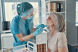 Young female paramedic using nasal swab