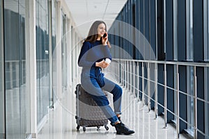 Young, female passenger at the airport, waiting desperately for her delayed flight color toned image; shallow DOF