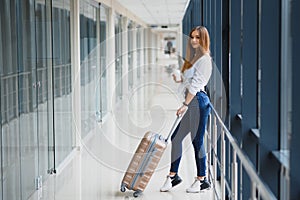 Young, female passenger at the airport, waiting desperately for her delayed flight color toned image; shallow DOF