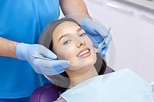 Young Female patient with pretty smile examining dental inspection at dentist clinic.