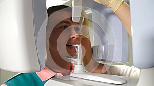 Young female Patient Standing In Dental X-ray Machine For Dental Radiography. Dentistry, Medicine And Healthcare Concept