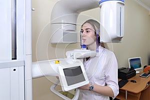 Young female patient standing in x-ray machine. Panoramic radiography