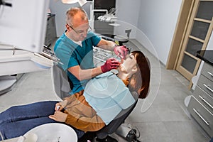 Young female patient takes a dental attendance in the dentist`s office. People, medicine, stomatology and health care