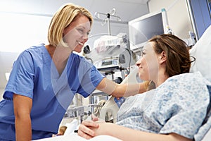 Young Female Patient Talking To Nurse In Emergency Room photo