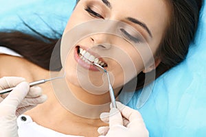 Young female patient visiting dentist office.Beautiful woman with healthy straight white teeth sitting at dental chair