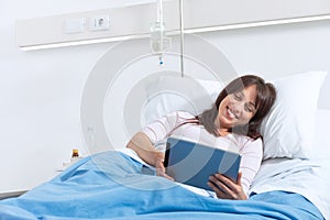 Young female patient watching video with digital tablet