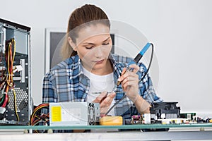 Young female pc technician fixing computer