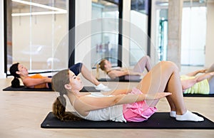 Young female performing set of exercises in pilates studio