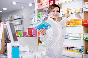 Young female pharmacist suggesting useful drug