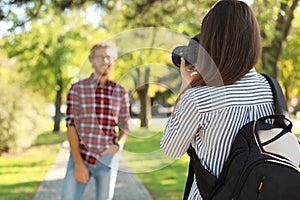 Young female photographer taking photo of man