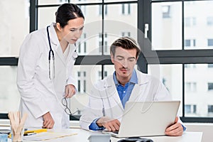 Young female physician asking for advice from her experienced male colleague