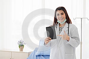 Young female physician   holding tablet and one finger point to the device